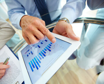 Close-up of a modern business team using tablet computer to work with financial data